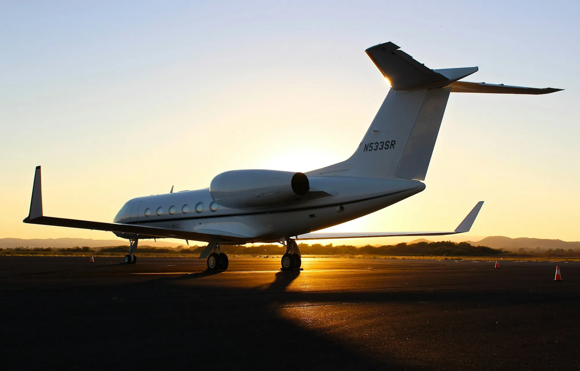 A private jet on an airport ramp at sunset