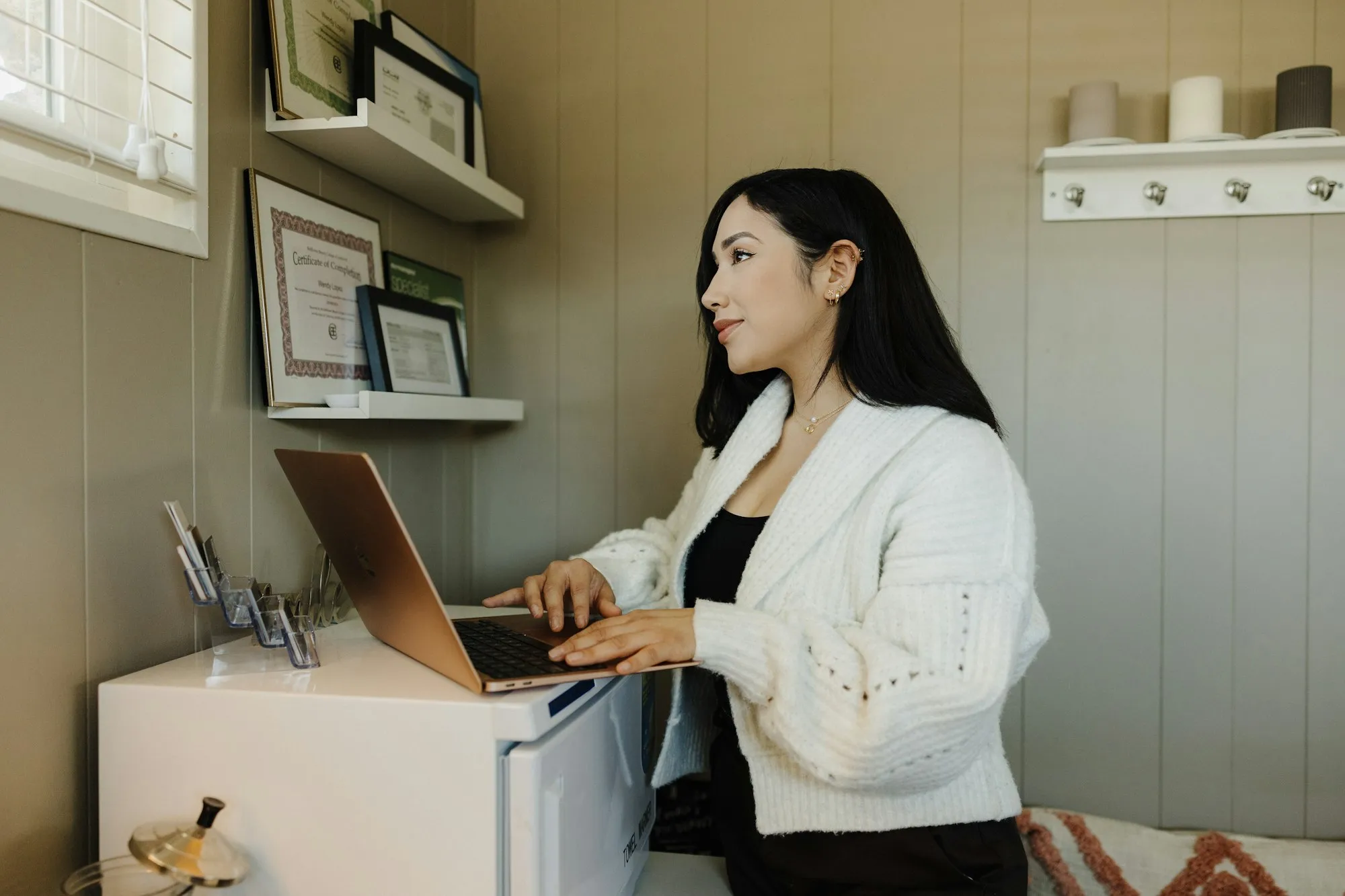 A business owner working on a laptop at a small office desk