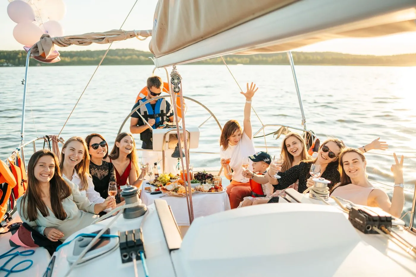 Friends celebrating on the deck of a yacht under way